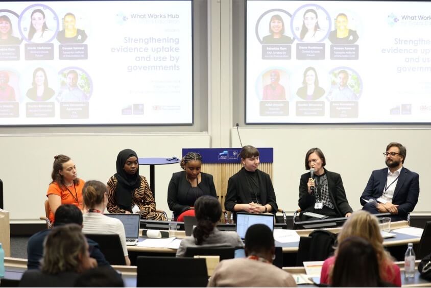 A group of panelists sits in front of a crowd and answers questions at a conference.