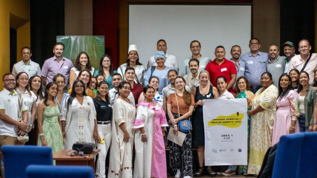 A group of people stand together, posing for a photo at a workshop exploring a Just Energy Transition in Colombia.